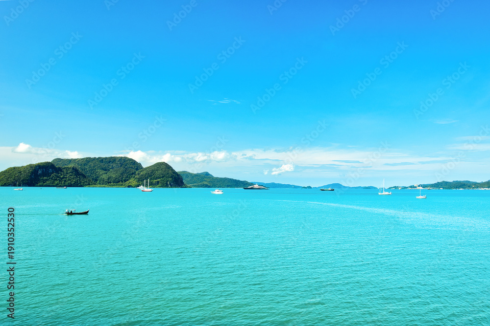 Obraz premium A beautiful view of Langkawi island against a beautiful blue sky with some boats in the distance on the horizon. Tropical scenery. located at Kedah, Malaysia - September 25 2024: