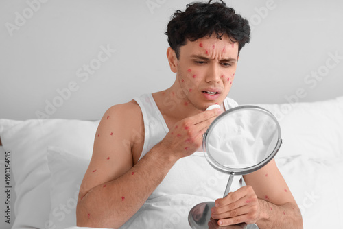 Ill young man with mirror a...