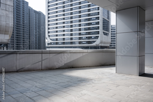 Fotografie Empty rooftop terrace surrounded by modern high-rise buildings in an urban setti