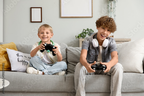 Cute brothers playing video games together at home