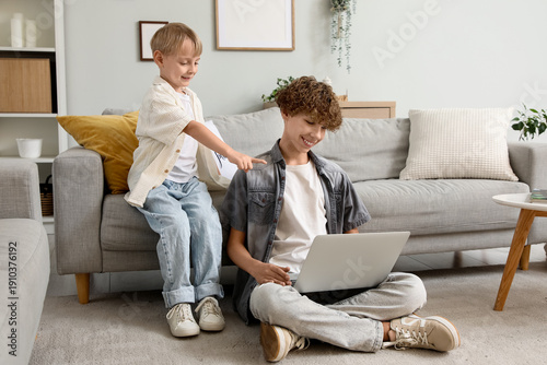 Fotografie Cute brothers using laptop together at home