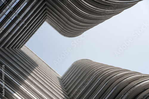 Vászonkép Modern high-rise building captured from low angle with geometric lines and struc