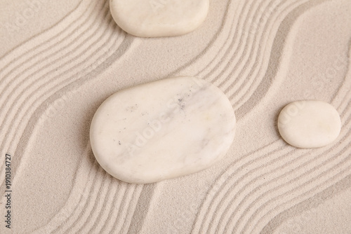 Photography Composition with spa stones and lines on light sand as background, closeup