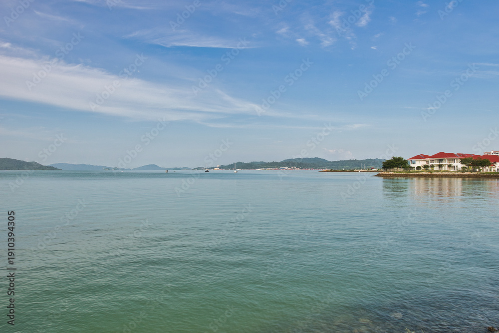 Obraz premium A beautiful view of Langkawi island against a beautiful blue sky with some boats in the distance on the horizon. Tropical scenery. located at Kedah, Malaysia - September 25 2024: