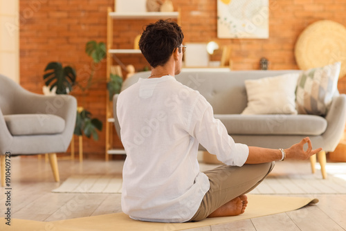Young man meditating on yog...