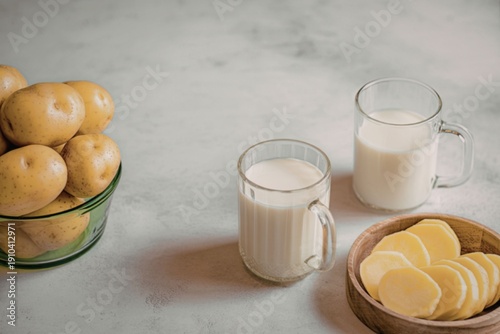 Fresh potatoes and potato milk on a marble surface