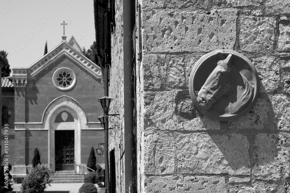 Fototapeta premium Borghi toscani in bianco e nero. L'architettura medievale dei borghi toscani, caratterizzata da pietra, cotto, riflette il periodo comunale con cinte murarie, torri, vicoli stretti e piazze. Italia. 