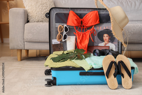 Open suitcase with beach ac...