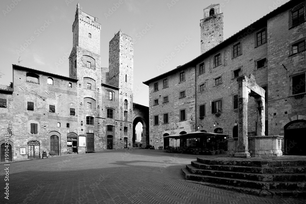 Fototapeta premium Borghi toscani in bianco e nero. La città turrita di San Giminiani ancora preservata dentro le antiche mura da cui svettano decine di torri. Siena,Toscana. Italia