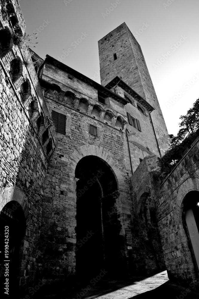 Naklejka premium Borghi toscani in bianco e nero. La città turrita di San Giminiani ancora preservata dentro le antiche mura da cui svettano decine di torri. Siena,Toscana. Italia