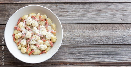 Gnocchi in a creamy sauce with bacon and cheese. Italian cuisine.