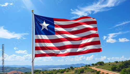 Liberian flag waving against blue sky with rolling hills and mountains, symbolizing national pride and independence
