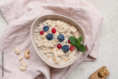 Bowl with tasty oatmeal, be...