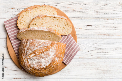 Wallpaper Mural Freshly baked bread slices on cutting board against white wooden background. top view Sliced bread Torontodigital.ca