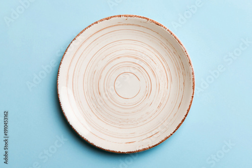 Top view of isolated of colored background empty round beige plate for food. Empty dish with space for your design