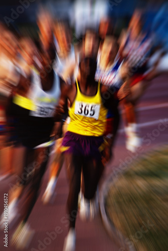 Foto Vintage 35mm film scan of long distance track race with zoom blur, group of runners on stadium track, grainy analog sports photography