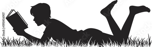 Silhouette of a young individual lying on the grass reading a book with their legs bent and raised in a relaxed position enjoying a moment of quiet study