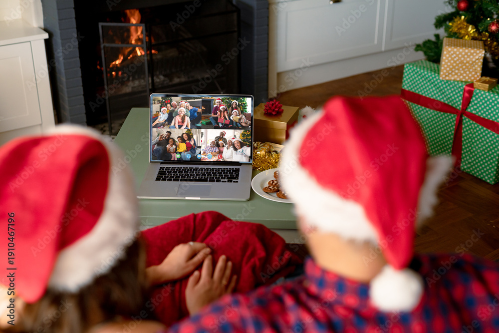 Obraz premium Caucasian couple having christmas video call with diverse people