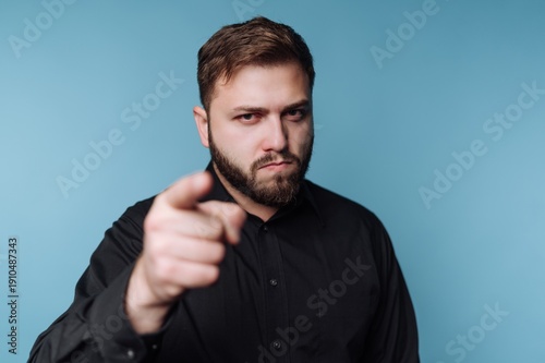 Canvas Print Confident man pointing directly at the viewer with a serious expression against