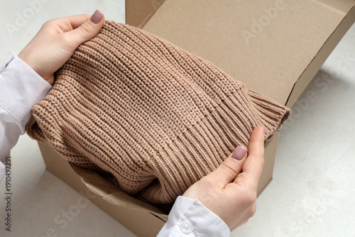 Woman packing clothes into ...