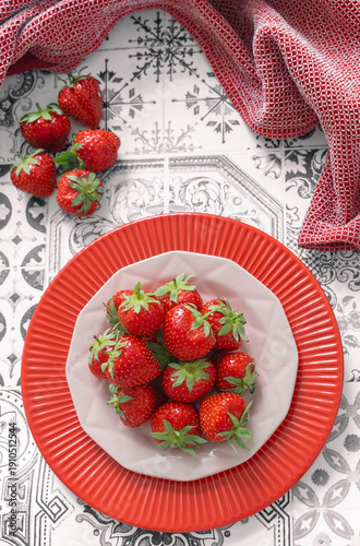 Fresh strawberries on a decorative plate with red kitchen towel