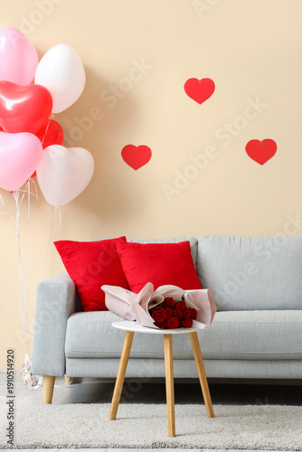 Interior of festive living room with grey sofa, coffee table and decorations for Valentine's Day celebration