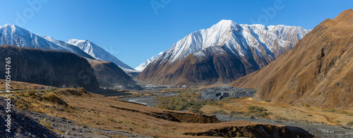 A view of a mountain valley surrounded by snow-capped mountains in the Caucasus