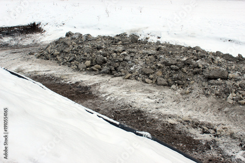 Polluted riverbank during winter cleanup — ideal for environmental remediation, contamination removal and municipal ecological intervention