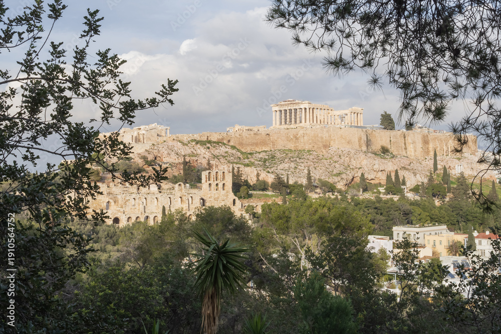 Fototapeta premium Parthenon temple on Acropolis hill in Athens framed by trees. Iconic Greek monument, ancient ruins and popular travel destination.