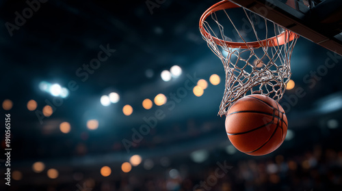 Hoop shot in game night. A basketball is above the hoop during a game. The crowd in the arena is watching and cheering.