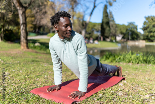 Vászonkép African American man doing yoga outdoors, finding relaxation, wellness, and heal