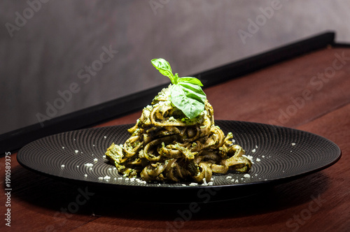 Makaron pesto z bazylią limonką na czarnym talerzu