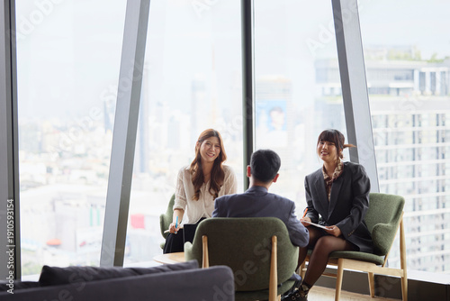 Smiling businesswomen communicating with male manager in team meeting at office