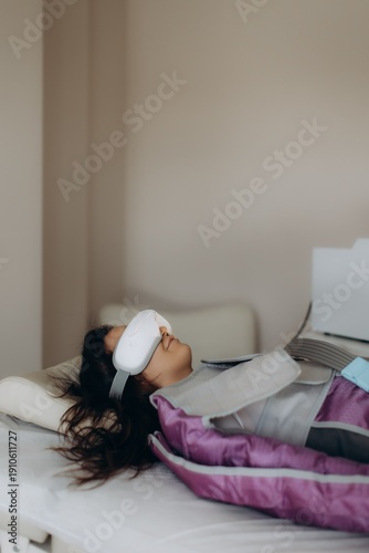Tableau sur toile Woman receiving beauty treatment with eye mask and pressotherapy