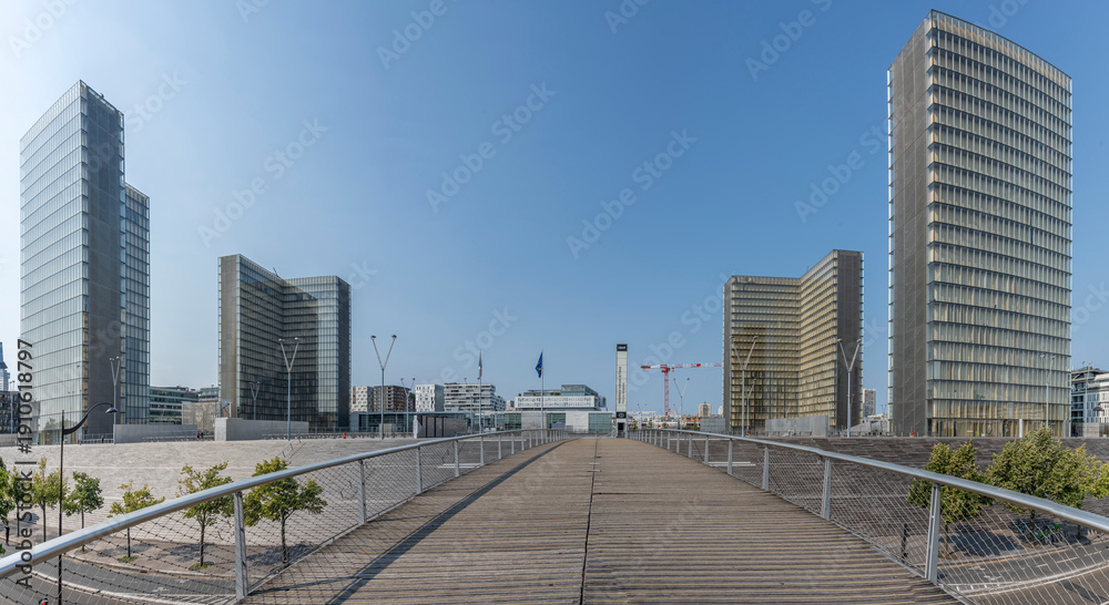 Obraz premium Paris, France - 08 15 2025: La Seine River. Panoramic view of the Simone de Beauvoir footbridge and the towers of the François-Mitterrand Library background