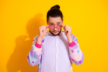 Young man in pastel pajama posing with pink sunglass for playful lifestyle advertising photo