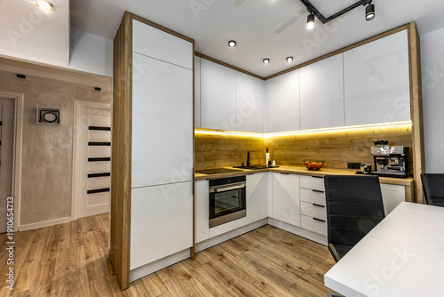 Modern built-in kitchen furniture, furniture with white high-gloss painted fronts, modern living room with kitchenette, apartment renovation, functional kitchen furniture with oven, induction hob, cof