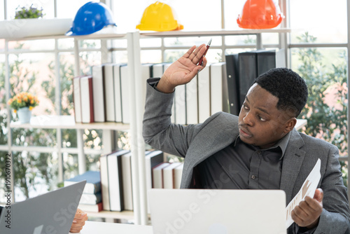 A Black engineer is giving his opinion at a meeting.