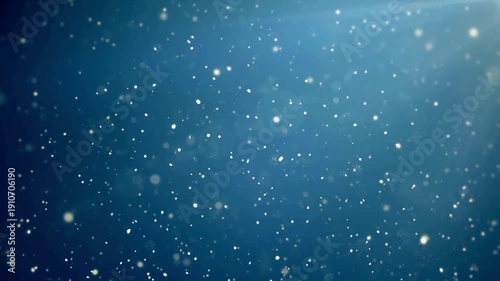 Snowflakes falling gently against blue background