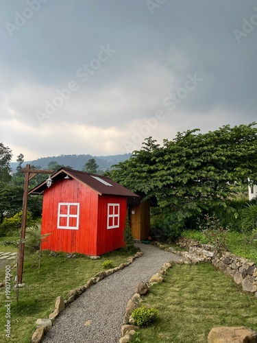 Принти на полотні An old wooden cottage sits on a green hill nestled within a rural mountain lands