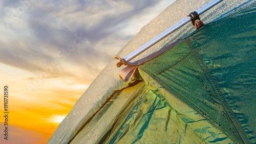 closeup tourustic tent in a water drop at the sunset time lapse scene