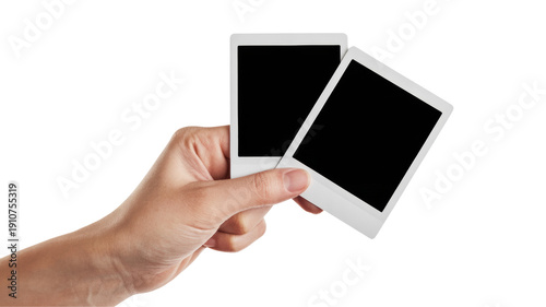 Hand holding two blank white instant photo frames with black background