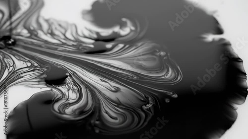 Black liquid pouring and spreading