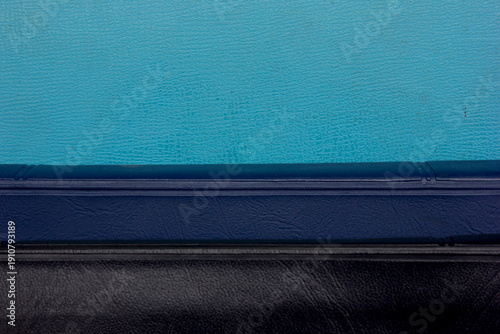 Close-up full frame photo of a stack of black and blue-covered Bibles, copy space background and texture.