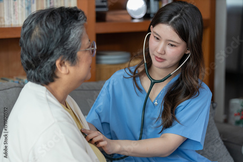 Photos Home visit nurse with stethoscope checking senior woman, providing compassionate healthcare and caregiver support