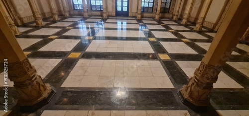 Grand interior hall of Lalbagh Palace in Indore featuring ornate classical columns and a beautiful geometric marble floor design