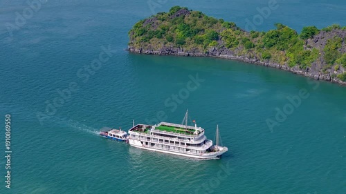 Boat exploring the dramatic karst landscape of Ha Long Bay, with emerald waters and towering rock pillars creating a breathtaking maritime panorama.