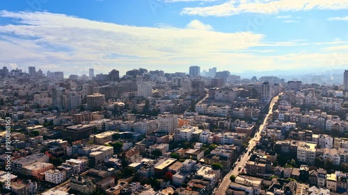 Long steep streets of San Francisco. Residential neighborhoods with high-rise buildings on the hills in sunny weather. Aerial view of the city.