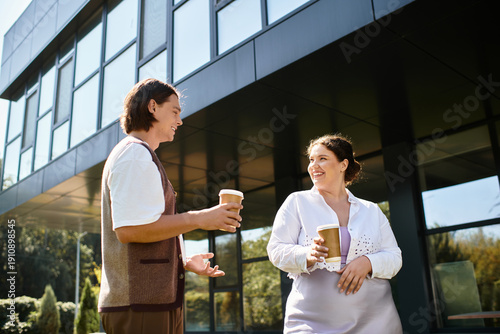 Billede på lærred Colleagues sharing smiles and coffee during a sunny workday in a modern office