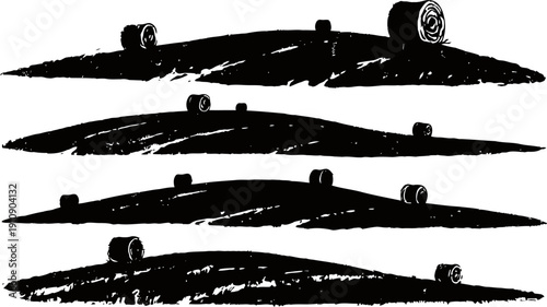 Silhouettes of agricultural fields with hay bales scattered on rolling hills at sunset